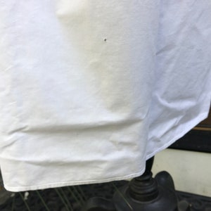 May include: White cotton fabric with a slight wrinkle. The fabric is smooth and has a slight sheen.