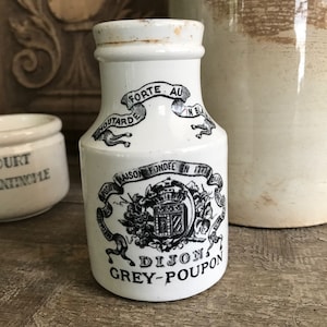 Puede incluir: Tarro de cerámica blanco con letras negras que dicen "FORTE AU", "MOUTARDE", "IN B", "MAISON FONDEE EN 1777", "DIJON" y "GREY-POUPON".