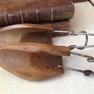 May include: A pair of wooden shoe stretchers with metal clips. The stretchers are numbered "9" and "10".