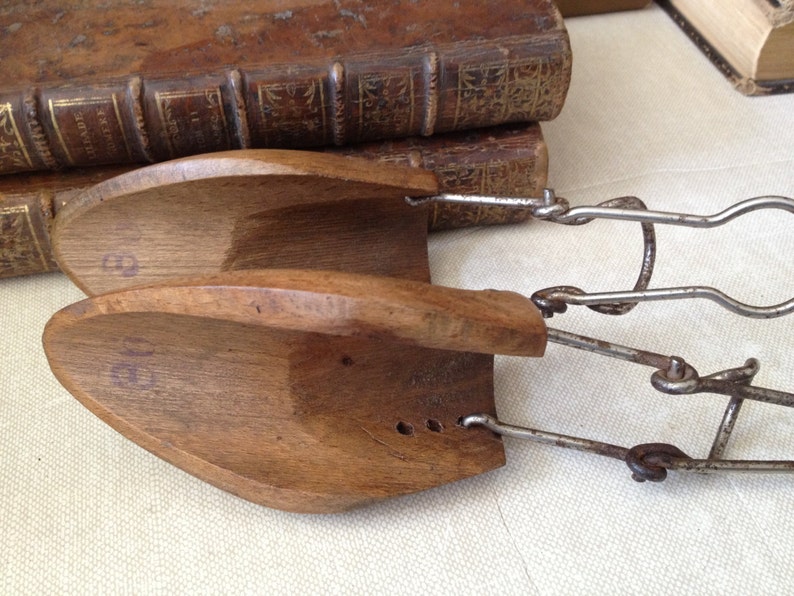 May include: A pair of wooden shoe stretchers with metal clips. The stretchers are numbered "9" and "10".