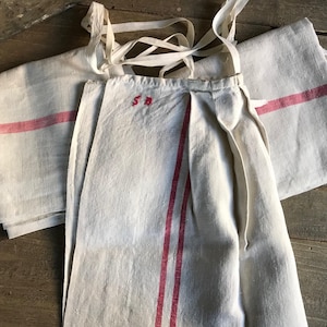 May include: Two white linen tea towels with red stripes. One towel has the initials "S.B." embroidered in red thread.