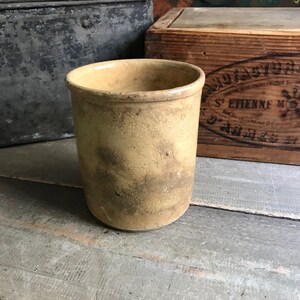 May include: A vintage, yellow ceramic crock with a crackled glaze. The crock has a round shape and a wide opening.