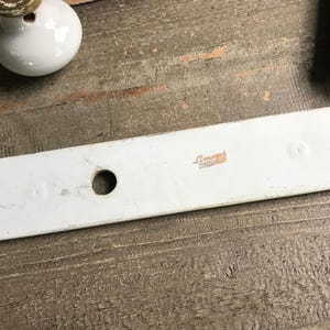 May include: White porcelain door hardware with a round hole and three smaller holes. The backplate has the text "Limoges France" printed on it.