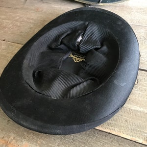 May include: Black felt top hat with a black satin lining and a gold label that reads "Thomas Bevington Belfast".