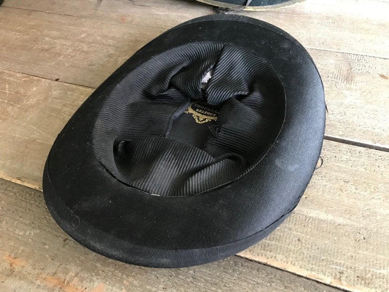 May include: Black felt top hat with a black satin lining and a gold label that reads "Thomas Bevington Belfast".