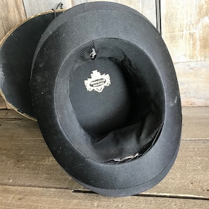 May include: Black top hat with a label inside that reads "Cromwell Hat Co."