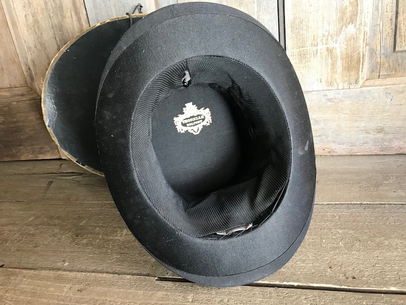 May include: Black top hat with a label inside that reads "Cromwell Hat Co."