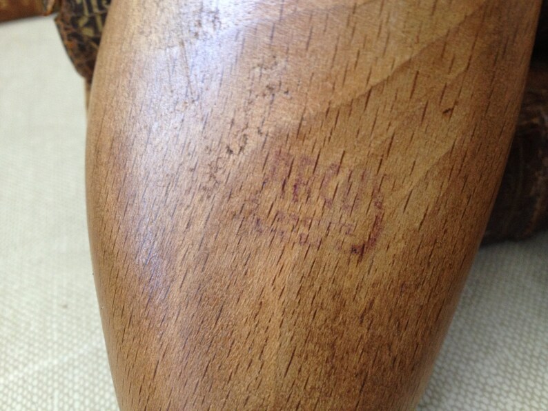 May include: A close-up of a wooden shoe stretcher with a red stamp that reads "ACCO 38".