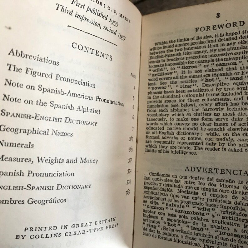 May include: A close-up of a book's contents page, featuring a list of topics related to Spanish language learning, including abbreviations, pronunciation, and dictionaries. The book's title is "Spanish-English Dictionary".