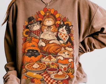 Könnte beinhalten: Ein braunes Sweatshirt mit Rundhalsausschnitt und einem Grafikdruck von mehreren Katzen, die für Thanksgiving gekleidet sind, umgeben von Kürbissen, Herbstblättern, einem gebratenen Truthahn, einem Kuchen und Mais.