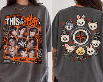 Könnte beinhalten: Ein anthrazitfarbenes T-Shirt mit einer Vorderseite, die acht Porträts der Musikgruppe Stray Kids sowie den Text "STRAY KIDS THIS & THAT" und "SKZ" zeigt. Die Rückseite zeigt acht Zeichentrick-Tierfiguren um einen Kompass herum.