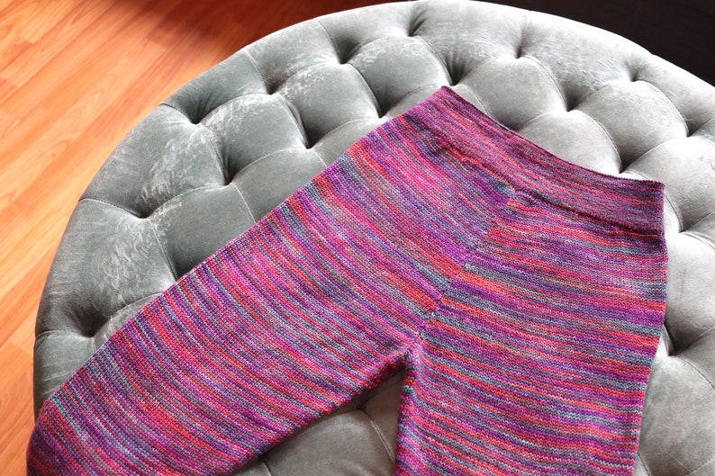 Peut inclure: Un legging ray&eacute; en rose, violet et gris. Le legging est fait d'un tissu doux et tricot&eacute;.