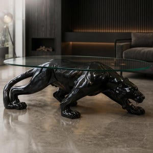May include: A coffee table featuring a glossy black sculpture of a crouching panther as its base, supporting a clear, oval-shaped glass top. The panther is depicted in a prowling stance with its mouth slightly open, showcasing detailed musculature.