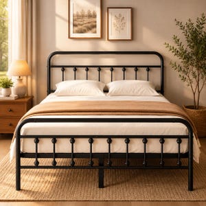 May include: A black metal bed frame featuring a rounded headboard and footboard with vertical spindles and decorative spherical accents. The bed is dressed with a white mattress, two white pillows, and a tan throw blanket draped across the center.