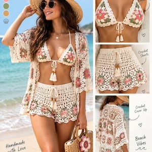 May include: A three-piece crochet set featuring a bikini top, shorts, and a cover-up, all crafted in an off-white yarn with floral granny square motifs in shades of pink and sage green. The bikini top and shorts include drawstring ties with tassels.