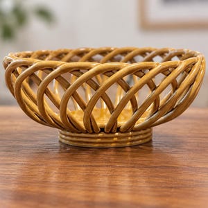 May include: A mustard yellow ceramic bowl featuring an openwork lattice design. The bowl has a circular base and curved, interwoven strips that form a basket-like structure with a glossy finish throughout the entire exterior surface.