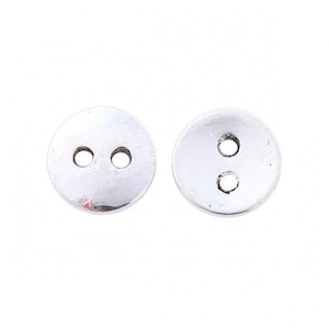 May include: Two silver metal buttons with two holes each.