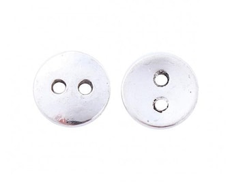 Op de afbeelding: Twee zilveren metalen knopen met elk twee gaten.