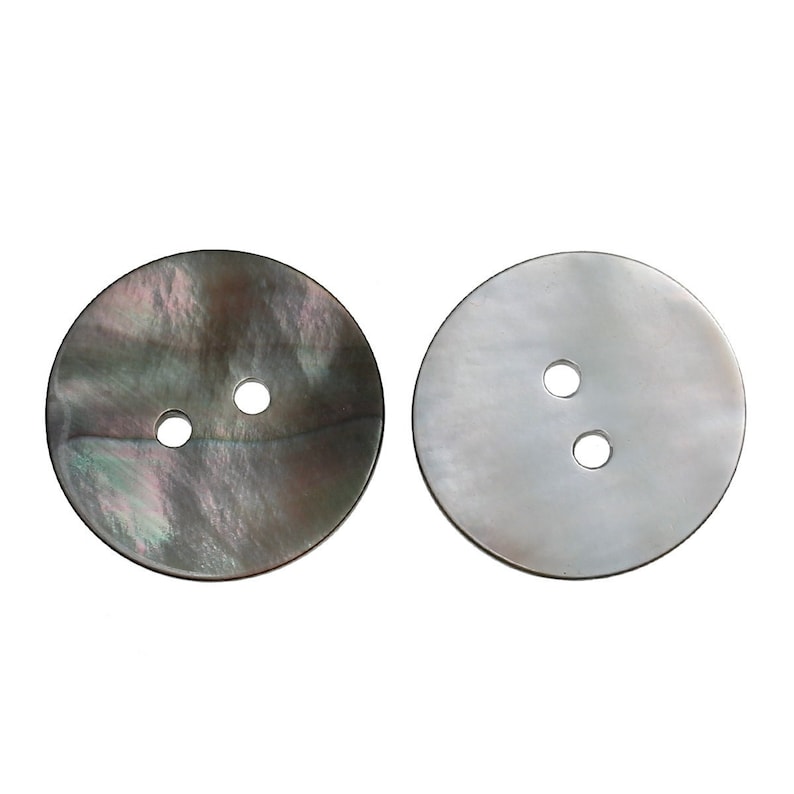 May include: Two round, two-hole, mother-of-pearl buttons. One button is black with iridescent swirls, the other is white.