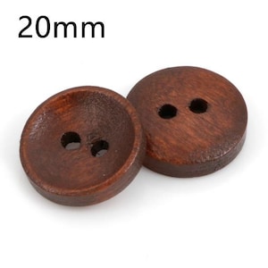 Könnte beinhalten: Zwei runde, dunkelbraune Holzknöpfe mit jeweils zwei Löchern zum Annähen. Die Knöpfe haben einen Durchmesser von 20 mm. Die Holzmaserung ist sichtbar. Die Knöpfe sind vor weißem Hintergrund.