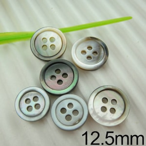 May include: Six round, iridescent buttons with four holes each. The buttons are a mix of white, gray, and black, with a pearlescent sheen. The text "12.5mm" is visible, indicating the button's diameter.