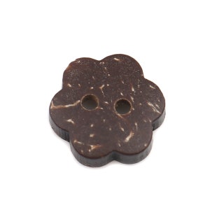 May include: A brown coconut shell button with a flower shape and two holes.