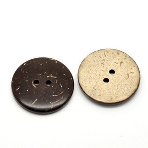 May include: Two round coconut shell buttons, one brown and one beige, with two holes each.