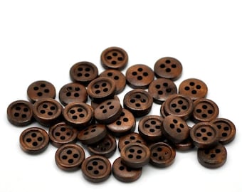 May include: A pile of brown wooden buttons with four holes each. The buttons are arranged in a random pattern.