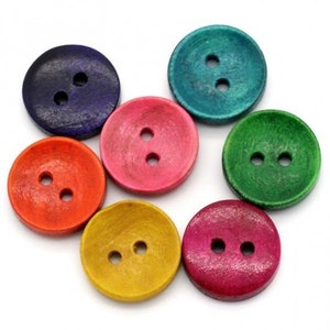 May include: Seven wooden buttons in various colors, including blue, green, pink, orange, and yellow. Each button has two holes and a slightly raised center.