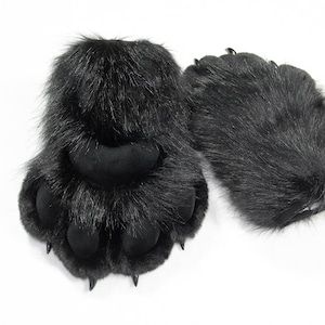 May include: A pair of black faux fur paw gloves featuring long, shaggy black synthetic hair, soft black padded toe beans, and sharp, pointed black claws extending from each of the four digits on the front of the hand-shaped coverings.