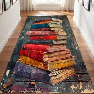 May include: A rectangular area rug featuring a three-dimensional printed design of a tall, uneven stack of weathered, multi-colored hardcover books resting on a dark, distressed wooden plank floor with scattered gold paint splatters.