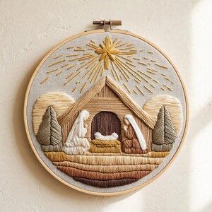Può includere: Un telaio da ricamo circolare con una scena della natività cucita su tessuto chiaro. Il disegno include una stalla in legno, due figure, una mangiatoia e due alberi, sormontati da una grande stella gialla con raggi dorati.