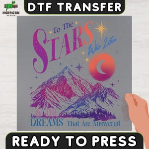 May include: A DTF transfer sheet featuring a mountain landscape graphic with a crescent moon and stars. The text reads To The Stars Who Listen and The Dreams That Are Answered. The design uses a gradient of purple, pink, orange, and blue colors.
