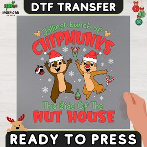 May include: A gray DTF transfer sheet featuring two cartoon chipmunks wearing red and white Santa hats. The text reads "Jolliest bunch of CHIPMUNKS This Side Of The NUT HOUSE" in red and green. Includes snowflake, candy cane, and holiday icons.