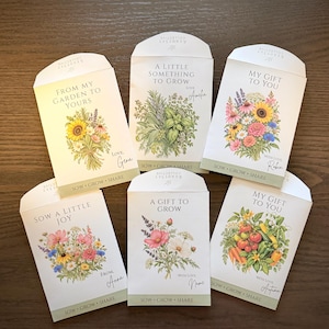Peut inclure: Six sachets de graines en papier blanc ornés d'illustrations botaniques de fleurs, d'herbes et de légumes. Chaque sachet porte des inscriptions comme "From My Garden To Yours", "A Little Something To Grow", "My Gift To You" et "Sow A Little Joy", avec "Sow Grow Share" imprimé en bas.