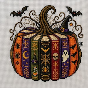 May include: A cross-stitch embroidery on white fabric depicting a pumpkin formed by a collection of vertical books. The design features Halloween motifs including bats, a spider web, a witch hat, a skull, a ghost, and a potion bottle in orange, purple, green, and black.