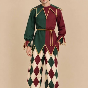 May include: A jester costume featuring a two-toned tunic in dark green and burgundy with gold trim and bells. The pants have a cream, green, and burgundy diamond pattern with gathered cuffs. Includes a matching two-toned jester hat with bells.