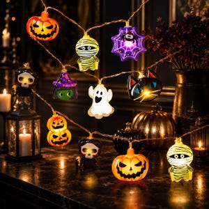 May include: A string of Halloween LED lights featuring various illuminated figures including orange jack-o'-lanterns, yellow mummies, a purple spider web, a green-faced witch, a white ghost, a black cat, and a skull-faced character on a copper wire.