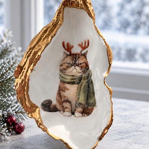 Festive Oyster Shell Featuring A Grumpy Reindeer Cat, Glossy Finish, And Elegant Gold Edging