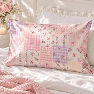 May include: A rectangular pillowcase featuring a patchwork design of various patterns including pink and purple gingham, floral prints, stripes, bows, hearts, and stars in shades of pink, white, and lavender on a soft fabric surface.