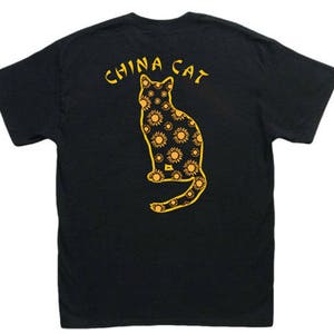 May include: Black t-shirt with a yellow graphic of a cat with a sunflower pattern. The text "CHINA CAT" is above the cat.