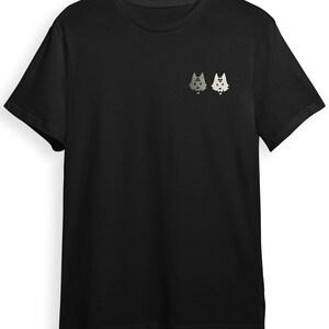 A black t-shirt with a small graphic design on the front, featuring two cartoon-like cat faces.