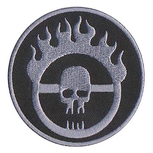 May include: Black and gray embroidered patch with a skull and flames. The skull is inside a circle with a line through it. The flames are around the circle.