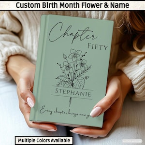 May include: A sage green hardback book featuring a black line art illustration of a flower bouquet. The text reads Chapter FIFTY, the name STEPHANIE, and the phrase Every chapter brings new growth. The book has a smooth, matte finish.
