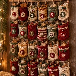Op de afbeelding: Een hangende adventskalender met vierentwintig gehaakte zakjes in rood, groen, crème en geel. Elk zakje is genummerd van 1 tot 24 met een ronde patch, bevat kleine voorwerpen en hangt aan een houten stok.