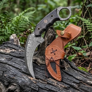 Peut inclure: Un couteau karambit incurvé doté d'une lame en acier damas à motifs et d'un manche en bois sombre avec un anneau pour le doigt. Le couteau est accompagné d'un étui en cuir beige avec une fermeture à pression en laiton et un laçage décoratif.