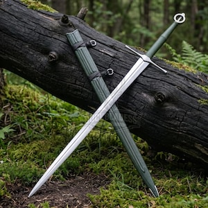 May include: A longsword with a silver-toned steel blade, a crossguard, and a dark olive green grip featuring a circular pommel. The sword is accompanied by a matching dark olive green scabbard with black leather-like straps and metal hardware.