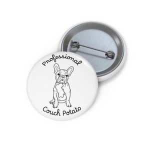 Könnte beinhalten: Ein runder, weißer Ansteckbutton mit einer schwarzen Strichzeichnung einer Französischen Bulldogge. Der Text "Professional Couch Potato" ist in schwarzer Schrift über und unter der Hundeillustration gedruckt. Die Rückseite zeigt eine silberne Nadel.