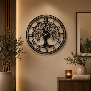 May include: A large, circular wall clock featuring a black metal frame with Roman numerals. The center of the clock displays a detailed, intricate silhouette of a tree with spreading branches and leaves. Two thin, gold-colored hands indicate the time.