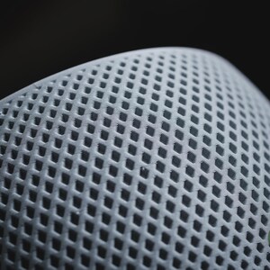 Puede incluir: Un objeto esf&eacute;rico de color gris claro que presenta un patr&oacute;n de rejilla en forma de diamante que se repite en su superficie curva. Un peque&ntilde;o logotipo circular verde con el texto blanco h3li&oslash; design es visible en la esquina inferior derecha.